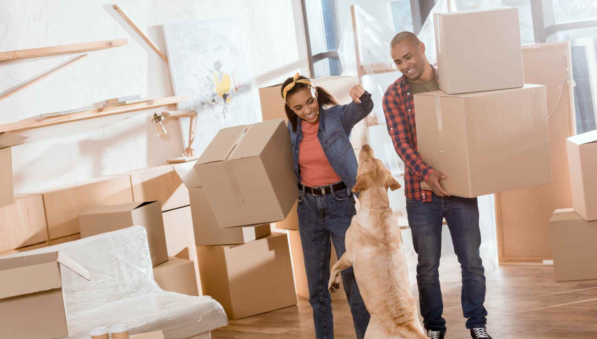 smiling couple moving with dog