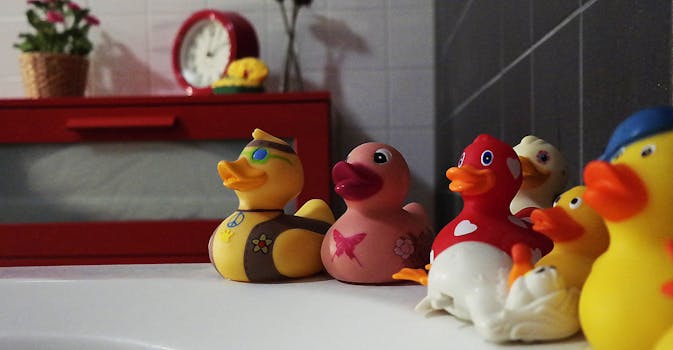 Colorful rubber ducks add fun to a modern bathroom setting with red accents.